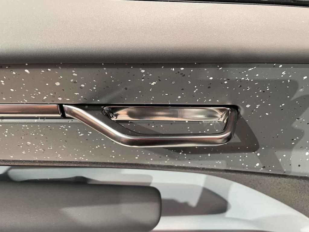 Volvo EX30 - kovová klika na vnitřní straně dveří
