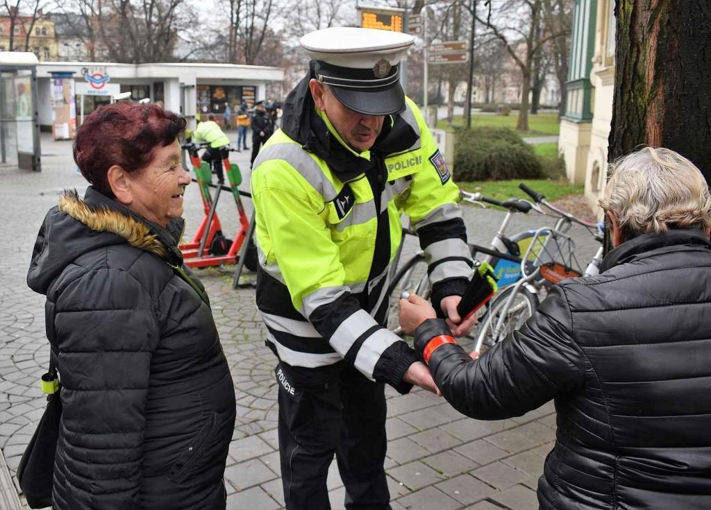 Policisté během preventivních akcí rozdávají reflexní pásky.