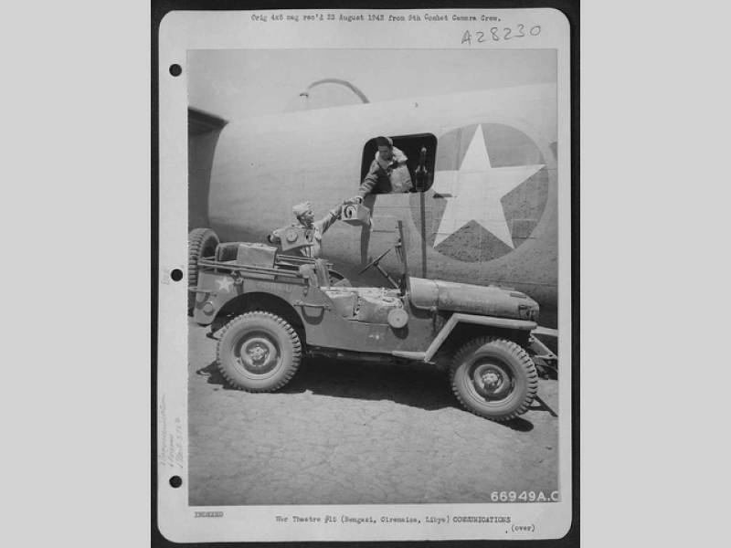 Americký Jeep Willys MB u bočního okna čtyřmotorového bombardéru B - 24 Liberator.