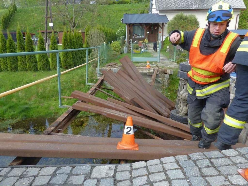 Řidič náklaďáku, který převážel dřevo k rodinnému domu ve Vápenné, skončil i s autem v říčce Vidnávce, 19. dubna 2024