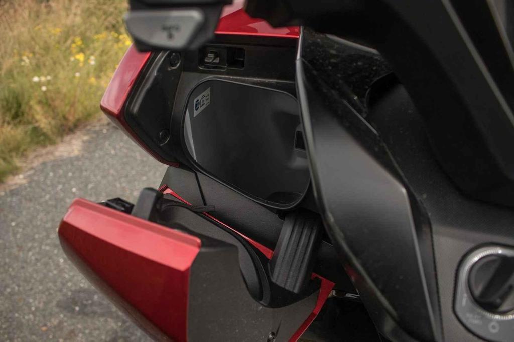 Pod levým řidítkem se skrývá šikovná přihrádka na mobil a drobnosti.