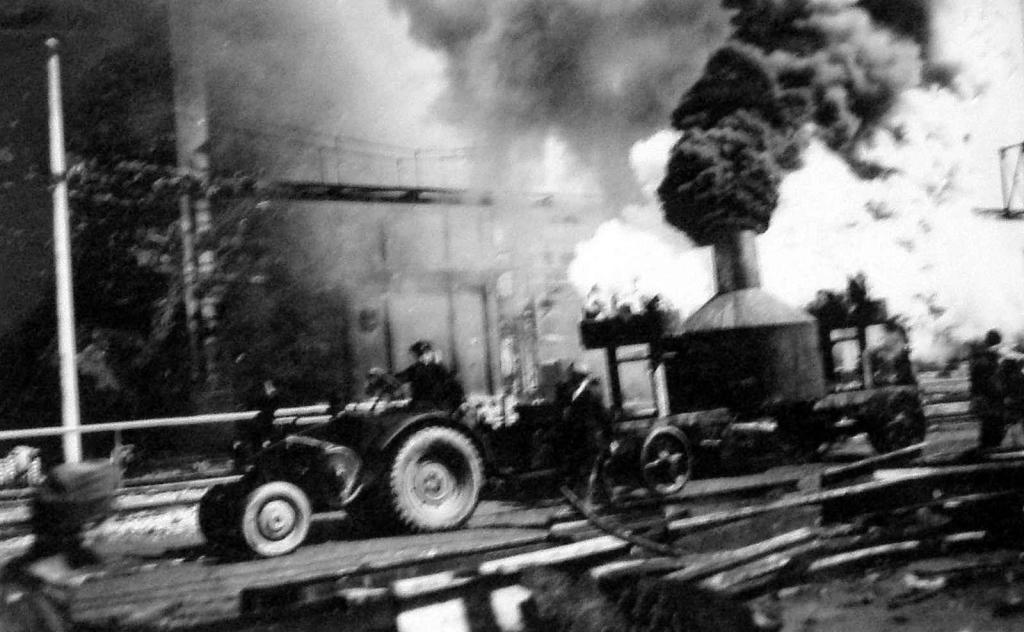 Traktor Lanz Bulldog a jím tažený valník vydávající mraky černého a žlutého dýmu. 30. července 1944.