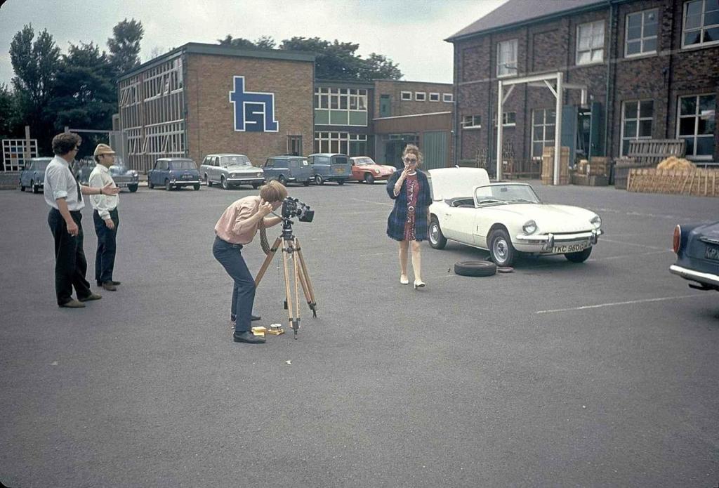 Fotografování modelky před Triumphem Spitfire fotografem Albertem Grigasem.