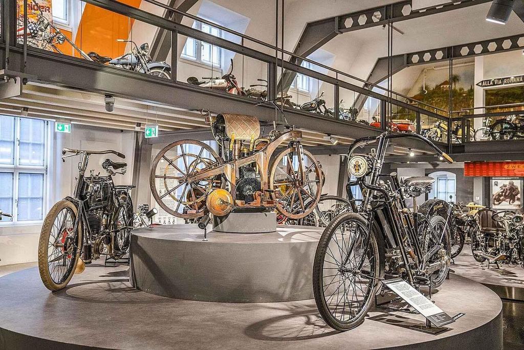 Daimler Reitwagen (uprostřed) společně s dalšími motocykly v Deutscher Zweirad und NSU Museu v Neckatsulmu.