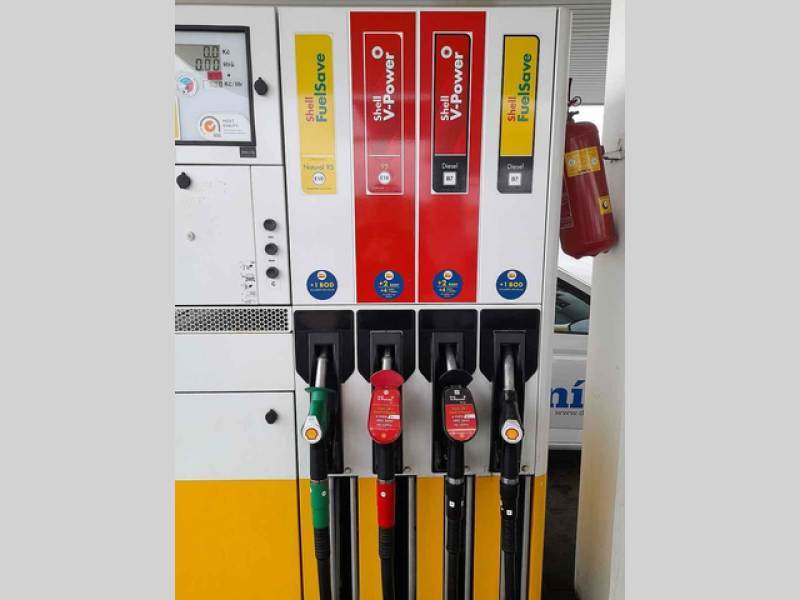 Pistole ve stojanu na čerpací stanici.