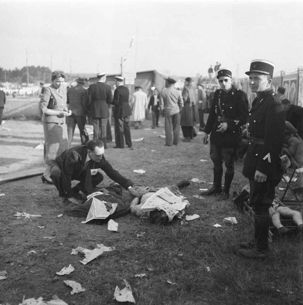 Le Mans 11. června 1955, okamžiky po katastrofě. Po srážce Leveghův vůz narazil do hlavní tribuny a rozletěl se na kousky, přičemž jeho letící trosky masakrovaly diváky jako šrapnely.