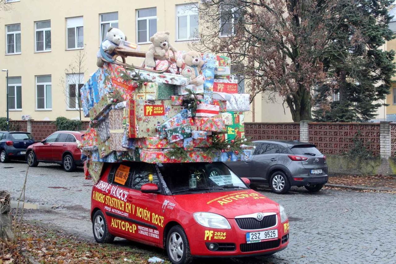 Auto se spoustou dárků na střeše budí rozruch vedle kruhového objezdu u nemocnice.