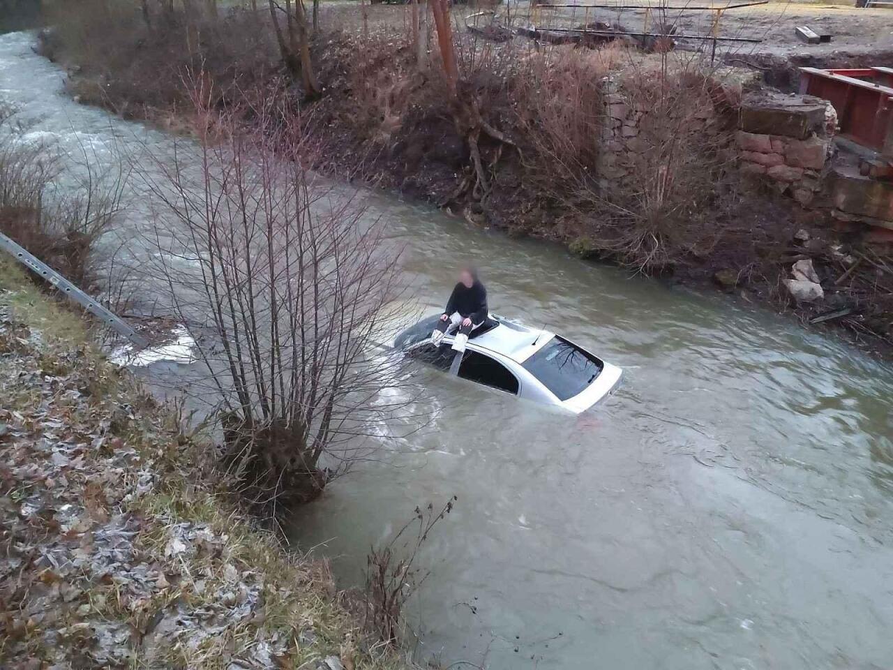 Fotka článku - S vozidlem sjel do řeky. Řidič čekal na záchranu na střeše auta